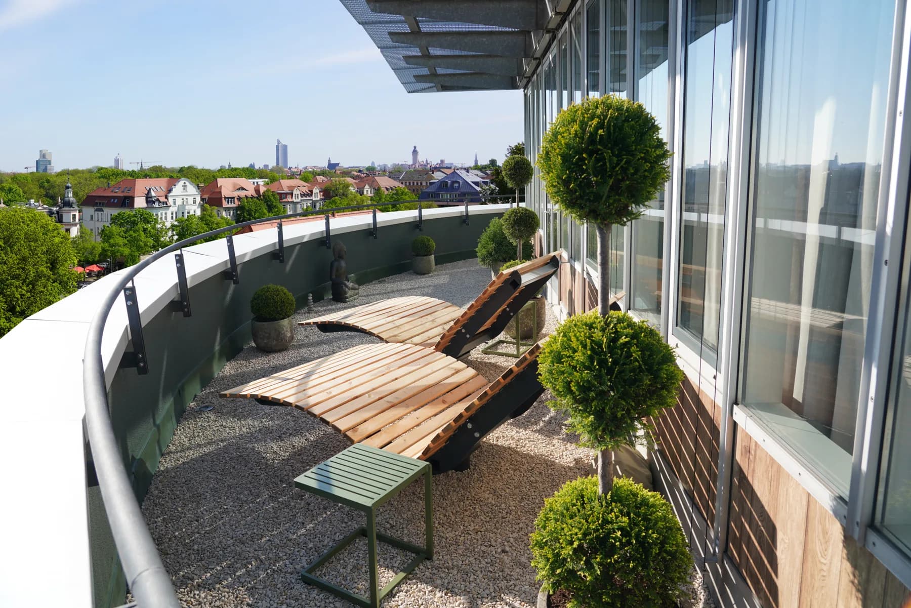 Dachterrasse der SKYLINE-Etage von RELAX plus mit Holzliegen und Blick über Leipzig