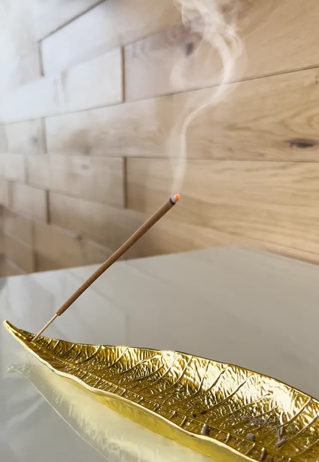 Raumduft-Diffusor im RELAX plus STUDIO auf einem weißen Sideboard vor der Holzpaneelwand