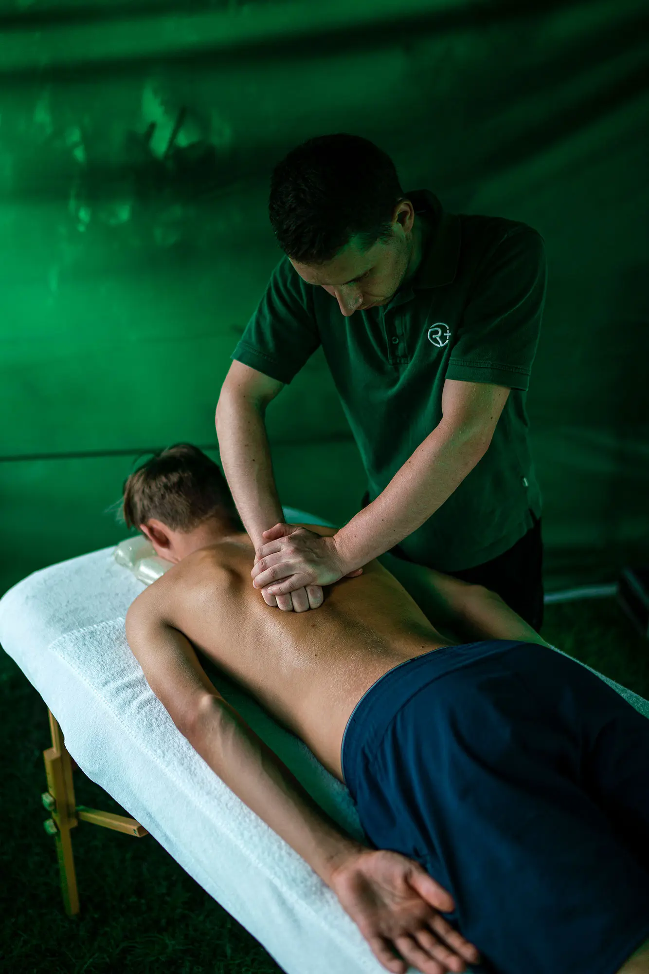 Masseuer von Relax plus massiert Tennisspieler auf einer Massageliege