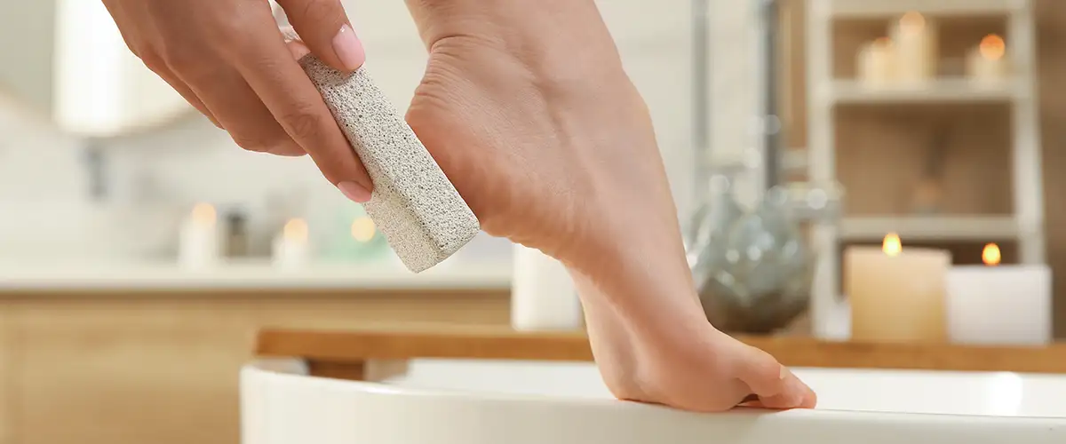 Frau entfernt Hornhaut an Ferse