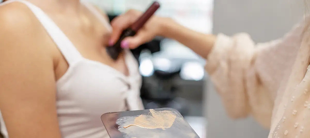 Kosmetikerin schminkt Dekolleté von Frau