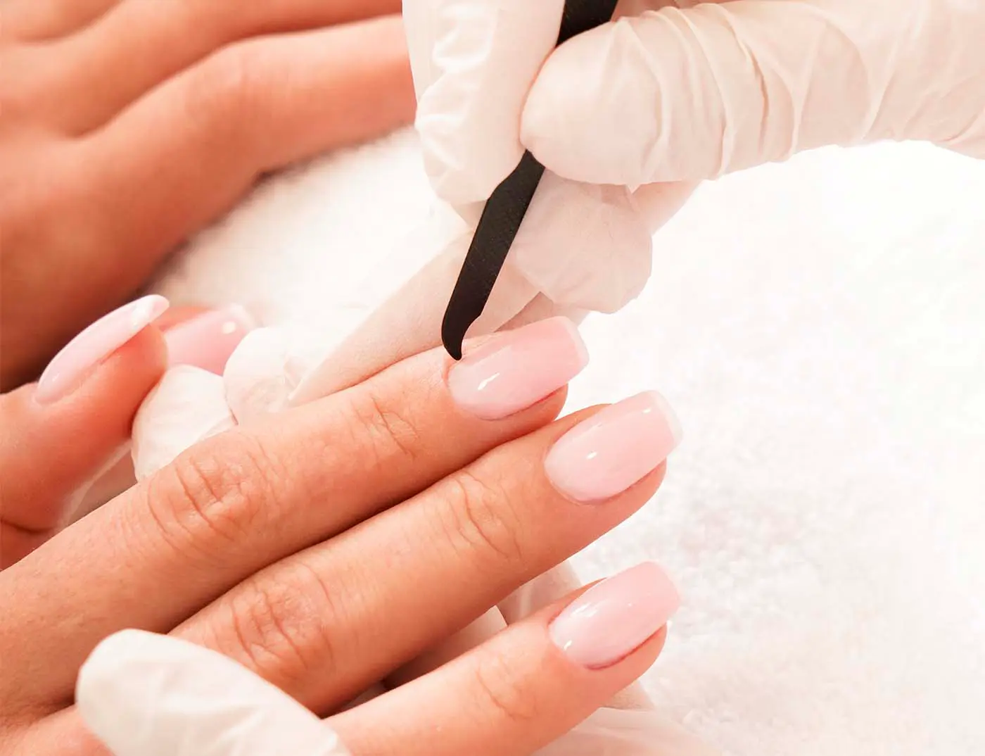 Kosmetikerin führt eine Maniküre bei einer Kundin durch