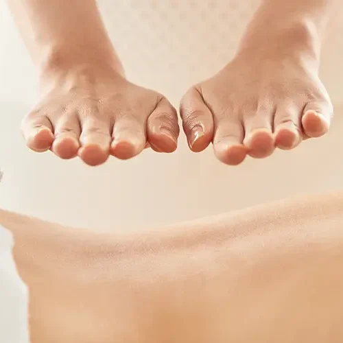 Zwei Hände schweben über dem Rücken einer Person während heilende Massagen stattfinden.