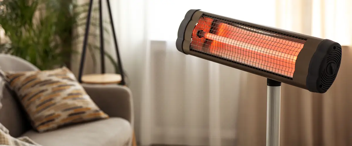 Infrarot-Heizstrahler in einem gemütlichen Wohnzimmer mit Sofa und Pflanzen im Hintergrund.