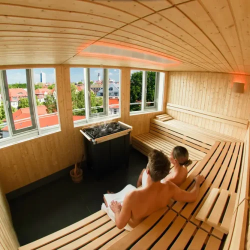 Ein Mann und eine Frau sitzen in der Skyline Saune von RELAX plus und genießen die Aussicht über Leipzig