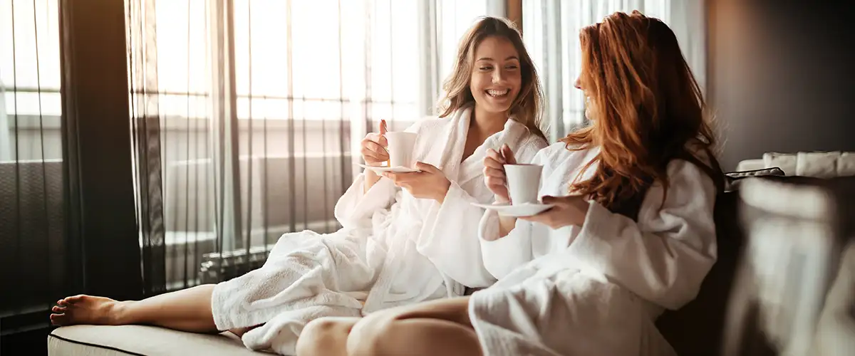 Zwei Frauen im Bademantel trinken einen Kaffee