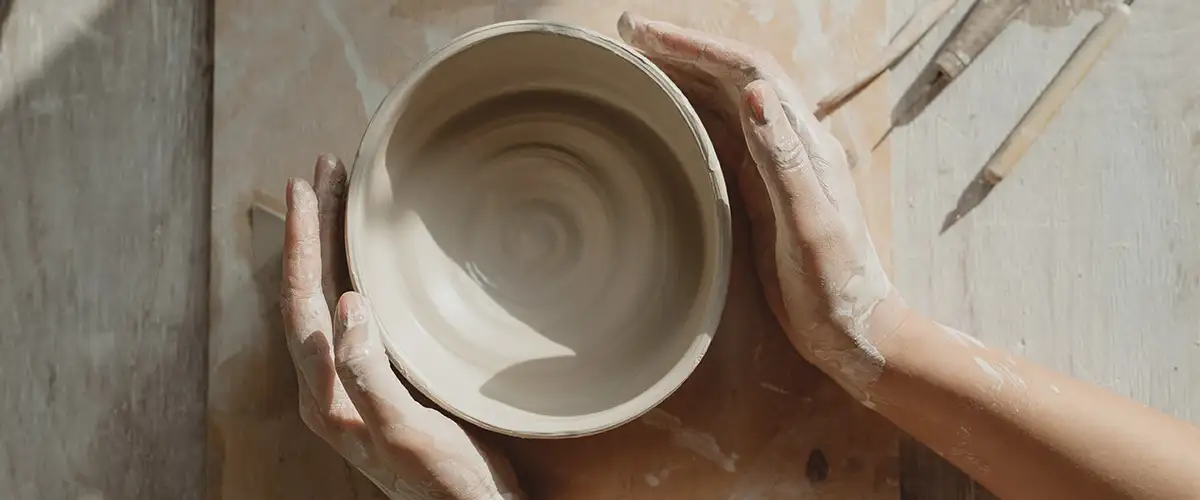 Frau umfasst getöpferte Schale