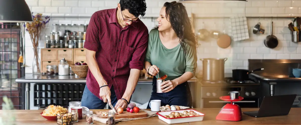 Pärchen steht in einer Küche und kocht gemeinsam