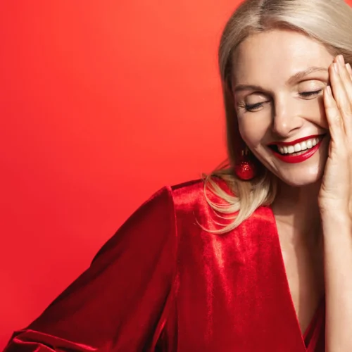 blonde Frau mit roten oberteil lacht
